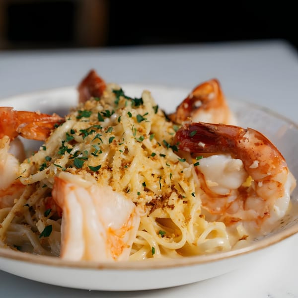 Viaggio Restaurant's shrimp scampi with linguine, parmesan, and parsley in a white bowl.